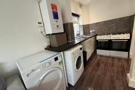 Well-equipped galley kitchen with dark countert...