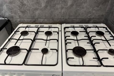 A clean twin gas hob setup with four burners on...