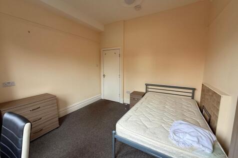 Bright, simply furnished bedroom with a double ...