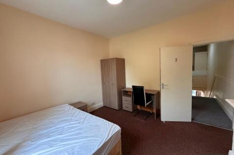 Bright, simply furnished bedroom with a double ...