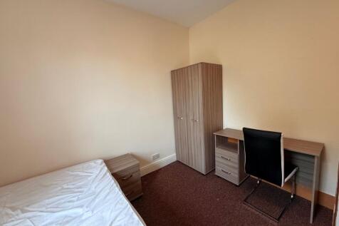 Bright, simply furnished bedroom with a single ...