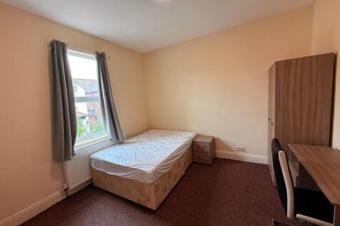 Bright, simply furnished bedroom with a large w...