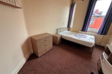 Bright furnished bedroom with a single bed by a...