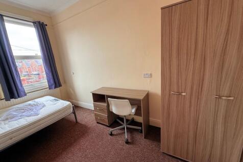 Bright single bedroom with a large window, fitt...