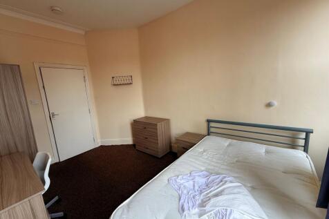 Bright, simply furnished bedroom with a double ...
