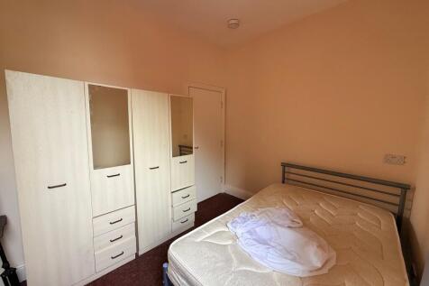 Bright, simply furnished bedroom with a metal d...