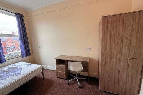 Bright bedroom with a large window, fitted ward...