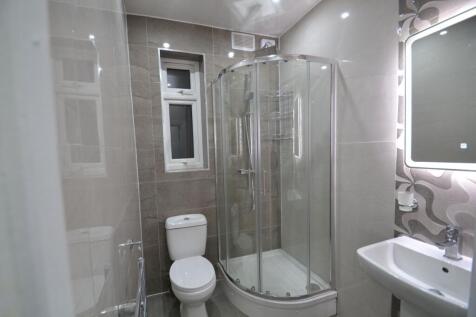 Modern tiled bathroom with a curved glass showe...