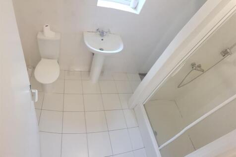 Bright white bathroom with tiled floor, pedesta...