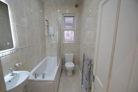 Bright, well-maintained tiled bathroom with a b...