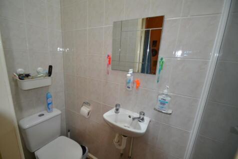 A clean and functional bathroom with tiled wall...