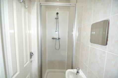 Bright tiled bathroom with a modern enclosed sh...