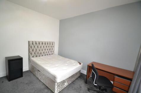 A tidy and minimalist bedroom featuring a comfo...