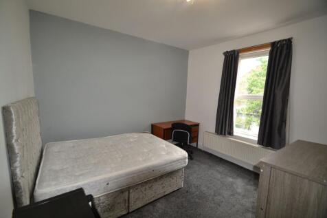 A cozy bedroom featuring a single bed with a pa...