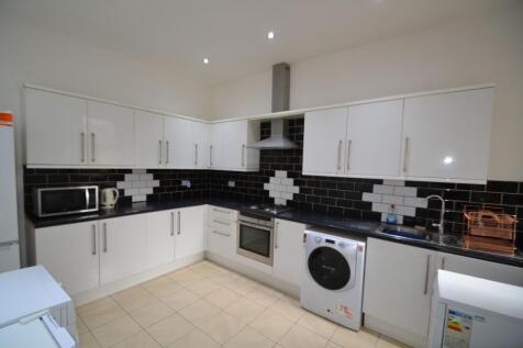 Modern kitchen featuring sleek white cabinets, ...