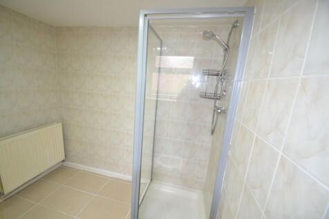 A clean, functional bathroom with a shower encl...