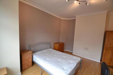 A cozy bedroom featuring a metal bed frame and ...