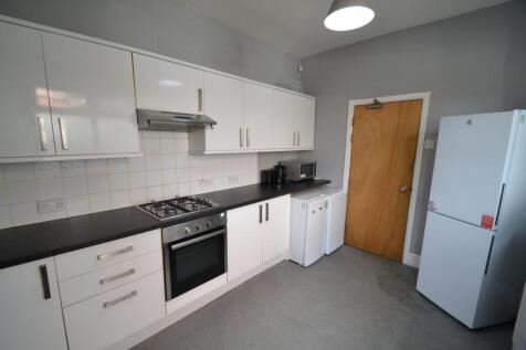 Modern, tidy kitchen with white cabinets, black...