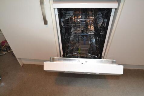 A modern built-in dishwasher with the door open...