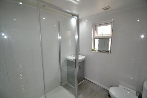 A modern, compact bathroom featuring a walk-in ...