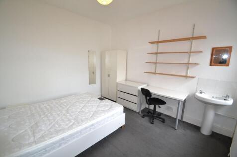 A simple, tidy single bedroom featuring a bed, ...