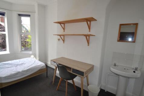 A cozy student bedroom featuring a single bed, ...