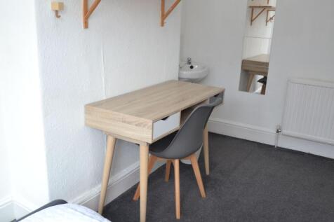 A clean and modern bedroom featuring a small de...