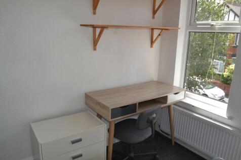 A compact study space with a wooden desk, a com...