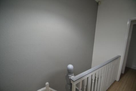 Neutral painted stairwell and landing with a wh...