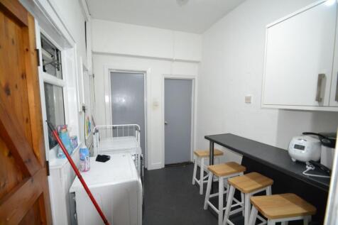 Long narrow kitchen/utility area with a breakfa...