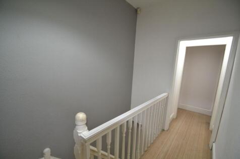 Bright, neutral upstairs hallway with painted w...