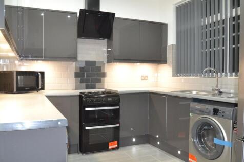 Modern kitchen featuring sleek gray cabinets, a...