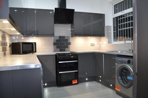Modern fitted kitchen with glossy grey cabinets...