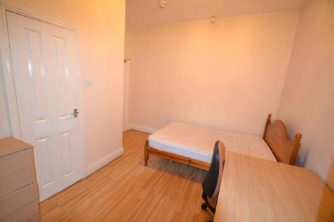 A cozy student bedroom featuring a single bed w...