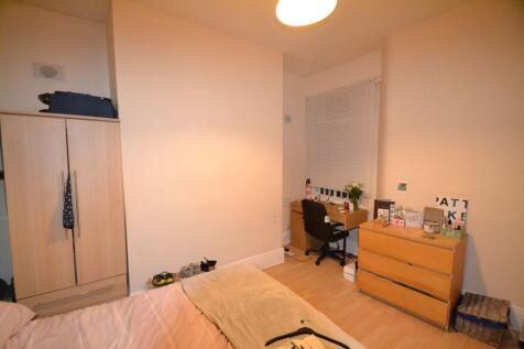 A cozy bedroom featuring a bed, a wooden wardro...