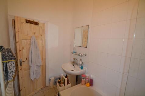 A compact bathroom featuring a bathtub, small s...