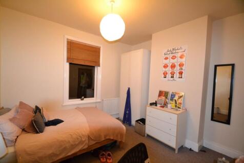 A cozy bedroom featuring a double bed with mult...