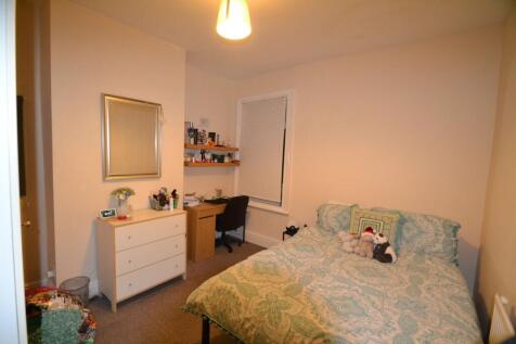 A cozy double bedroom featuring a large bed dec...