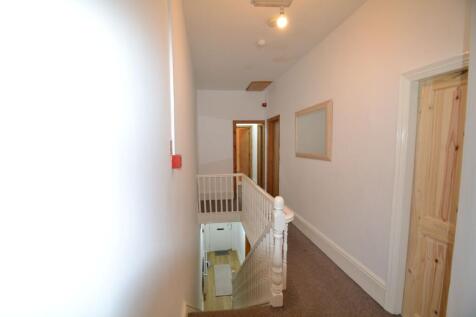 Bright upstairs hallway with neutral walls, car...