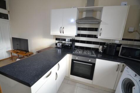 Modern fitted kitchen with dark worktops, black...