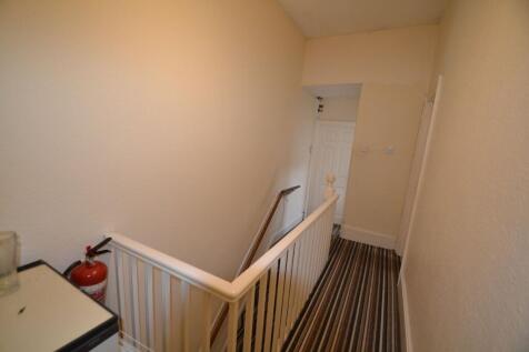 Narrow upstairs landing with striped carpet, wh...