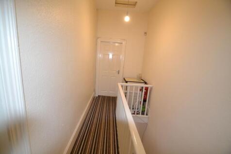 Bright upstairs landing with striped carpet, fr...