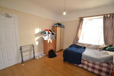 Bright bedroom with large window, wooden floors...