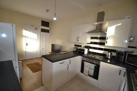 Bright modern kitchen with white cabinets, blac...