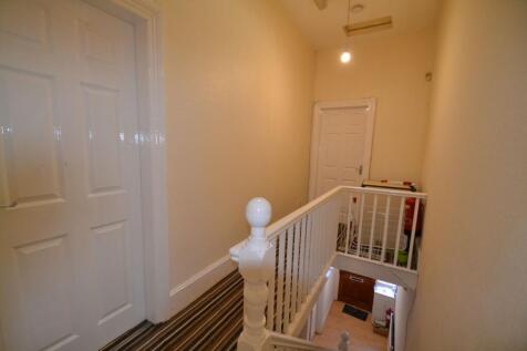 Bright upper landing with a painted white balus...