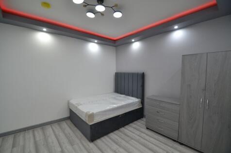 A modern, tidy single bedroom featuring a comfo...