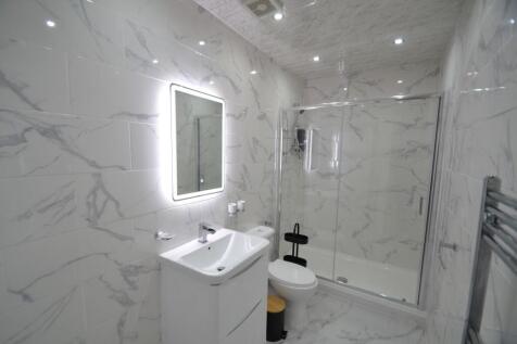 Modern and sleek bathroom with large marble-eff...