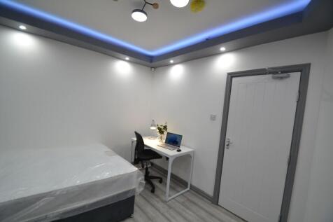 A clean and modern single bedroom featuring a w...