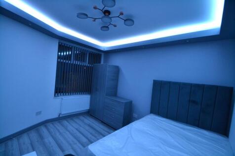 Modern bedroom featuring a stylish headboard, a...