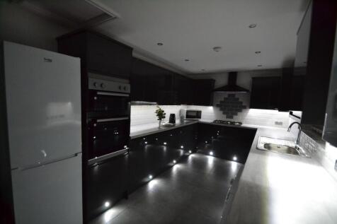 Modern kitchen with sleek dark cabinetry, white...